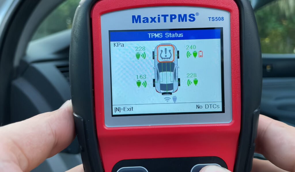 alt="Car mechanic using professional tools to replace or calibrate TPMS sensors