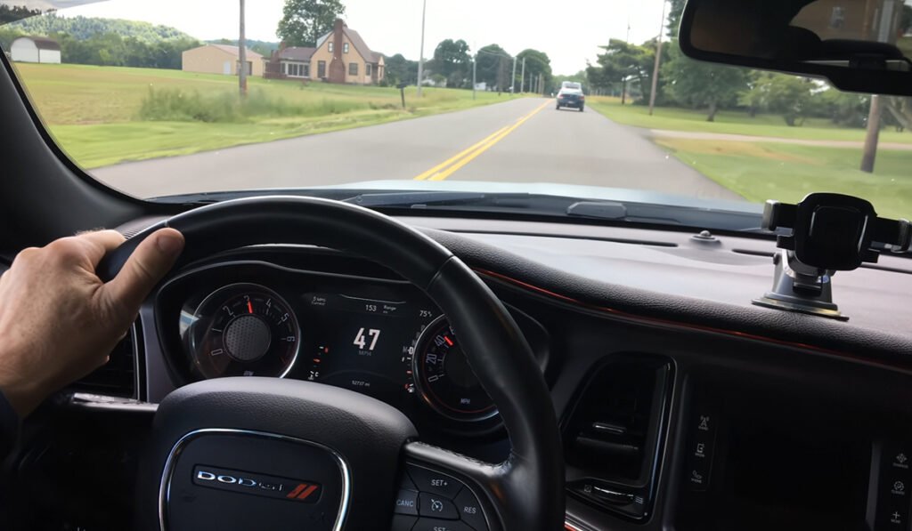 Car driving safely with properly functioning choose TPMS sensors monitoring tire pressure.
